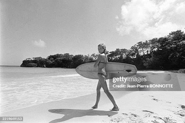 Séance de surf pour Marlène Jobert sur une plage de la Jamaïque pendant ses vacances en février 1972