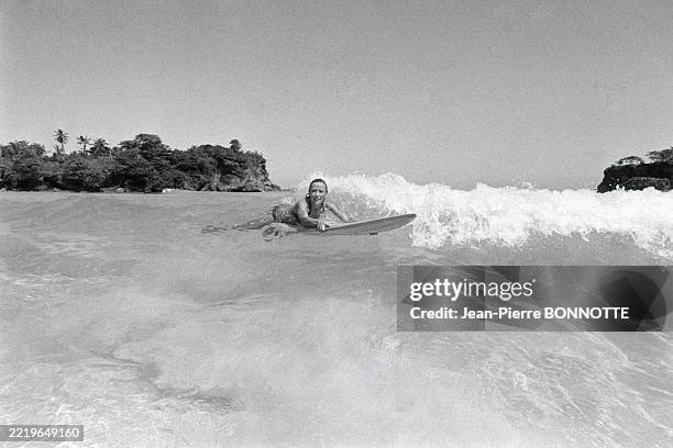 Séance de surf pour Marlène Jobert sur une plage de la Jamaïque pendant ses vacances en février 1972