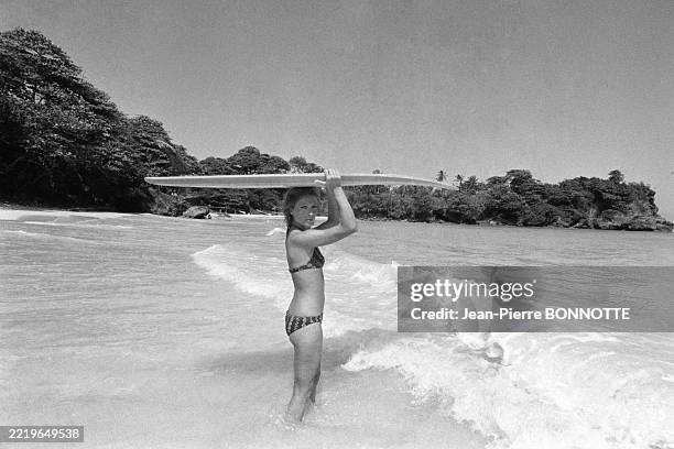 Séance de surf pour Marlène Jobert sur une plage de la Jamaïque pendant ses vacances en février 1972