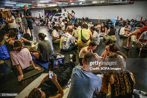 Israelis seen taking shelter in a public underground facility during an Iranian ballistic missile barrage. Israelis gather at public shelters during...