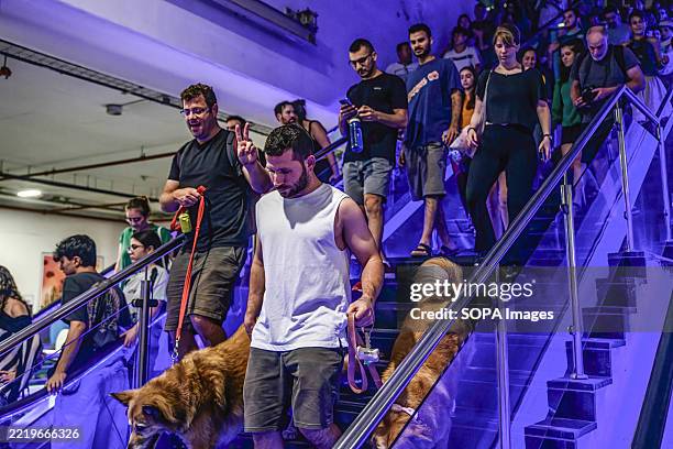 Israelis seen taking shelter in a public underground facility during an Iranian ballistic missile barrage. Israelis gather at public shelters during...