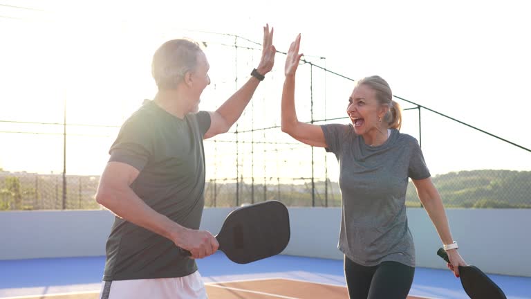 https://media.gettyimages.com/id/2219680696/video/mature-elderly-couple-play-pickleball-together.jpg?b=1&s=640x640&k=20&c=GRLJYTiRTcp8_mjLJIY-6zdu_YQoJeebhDUGOv_8prQ=
