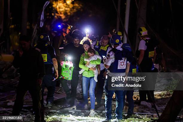 Residents are evacuated from a damaged building after ballistic missiles fired from Iran struck Petah Tikva, Israel, on June 16, 2025.