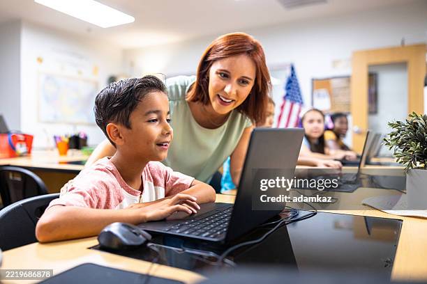elementary students learning in the computer lab with their teacher - computer lab kids stock pictures, royalty-free photos & images