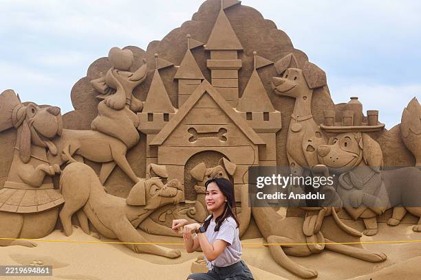 People engage with different cartoon sand sculptures during the Fulong International Sand Sculptures Art Festival, at Fulong beach in New Taipei,...