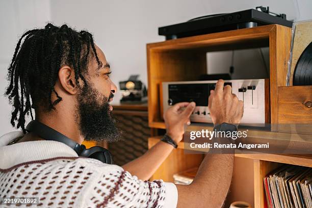 joven escuchando discos de vinilo - equipo de alta fidelidad fotografías e imágenes de stock