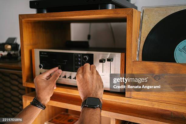 joven escuchando discos de vinilo - equipo de alta fidelidad fotografías e imágenes de stock