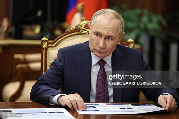 In this pool photograph distributed by the Russian state agency Sputnik, Russia's President Vladimir Putin meets with the Governor of Sevastopol in...
