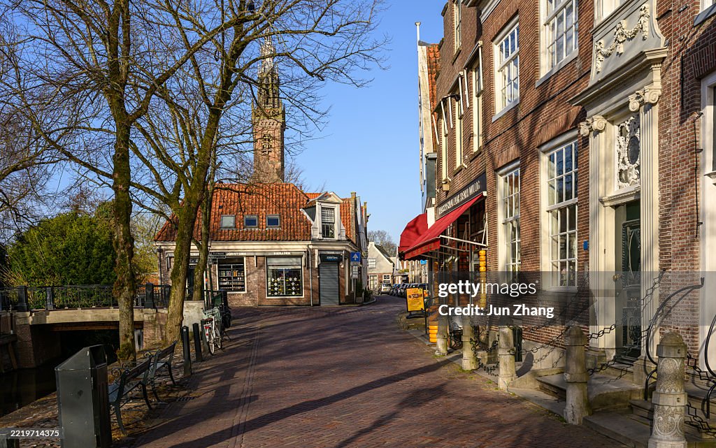 Historic town Edam in early morning - Tree shadows on brick paved streets along the canal