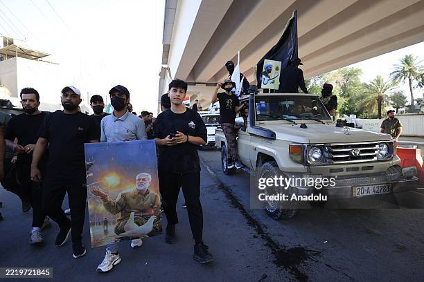 Supporters of Asa'ib Ahl al-Haq Movement, Iranian-backed Shiite militia group gather at Green Zone during a demonstration in support with Iran and...