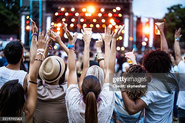 back view of friends with raised arms on music concert. - concert stock pictures, royalty-free photos & images