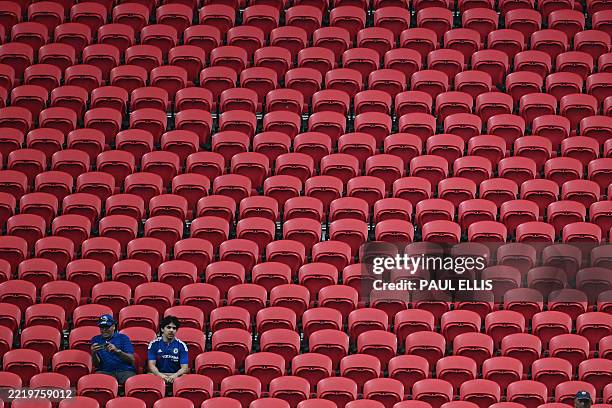 Two Chelsea's supporters sit in an empty tribune during the FIFA Club World Cup 2025 Group D football match between England's Chelsea and US Los...