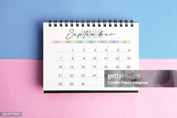 september desk calendar for 2025 year on blue and pink color background with shadow. - setembro imagens e fotografias de stock