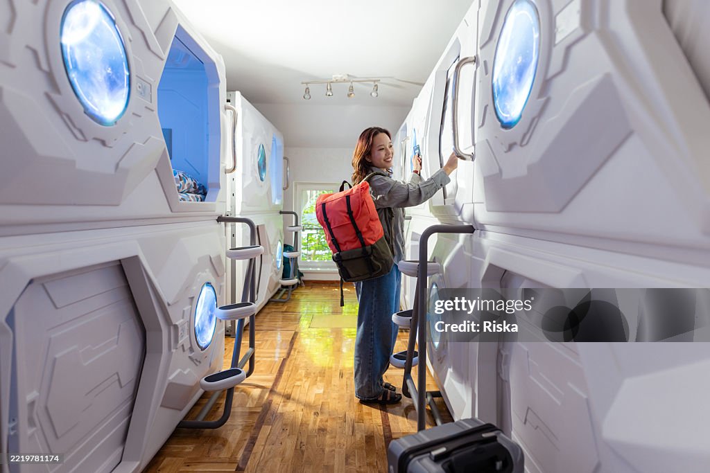 Young traveler exploring futuristic capsule hostel design for unique accommodations