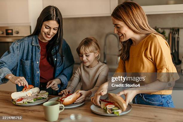 happy family preparing sandwiches in the kitchen - making a sandwich stock pictures, royalty-free photos & images