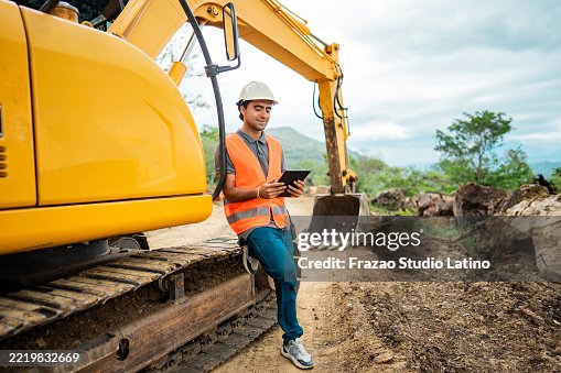 Construction worker using a digital tablet on a construction site Construction worker using a digital tablet on a construction site