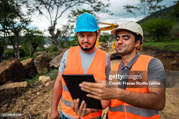 construction workers using a digital tablet at a construction site - mining tablet stock pictures, royalty-free photos & images