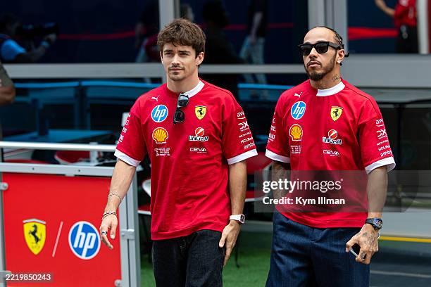 Charles Leclerc of Monaco and Ferrari walks in the paddock with Lewis Hamilton of Great Britain and Ferrari during previews ahead of the F1 Grand...