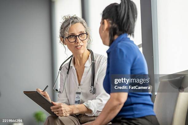 doctor consulting with patient during a medical appointment in clinic setting - kontroll bildbanksfoton och bilder