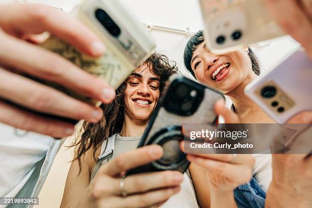 multiracial group of business people using mobile phones together in modern office. - telecommunications equipment stock pictures, royalty-free photos & images