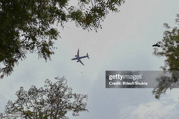Commercial aeroplane is seen over of site of crashed Air India Boeing 787, on June 13, 2025 in Ahmedabad, India. An Air India Boeing 787 Dreamliner,...