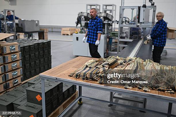 Workers perform their tasks in the production line of small caliber ammunition during the opening of Mesko SA's New Ammunition Production Hall on...