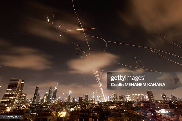 Israeli air defence systems are activated to intercept Iranian missiles over the Israeli city of Tel Aviv early on June 18, 2025. Israel and Iran...
