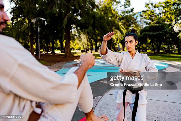 karate athlete training with friend on the public park - aikido stock pictures, royalty-free photos & images