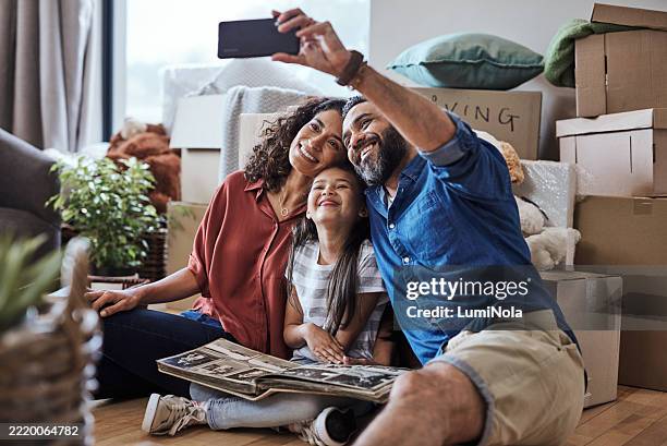 happy family taking a selfie at their new home during moving day - mudar de casa imagens e fotografias de stock