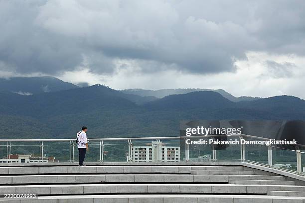 Person stands observing the overcast view from Nimman Hill on June 14, 2025 in Chiang Mai, Thailand.