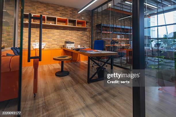 empty industrial-style private office interior with brick wall, orange storage, glass partition, and wooden floor in contemporary workspace - private office stock pictures, royalty-free photos & images