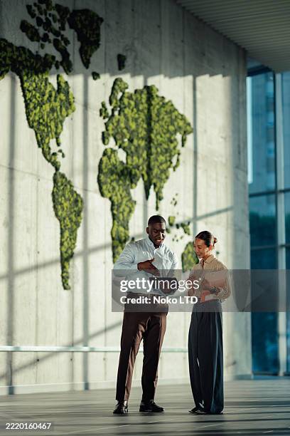 managers discussing global business strategy using digital tablet in modern office - world map office stock pictures, royalty-free photos & images