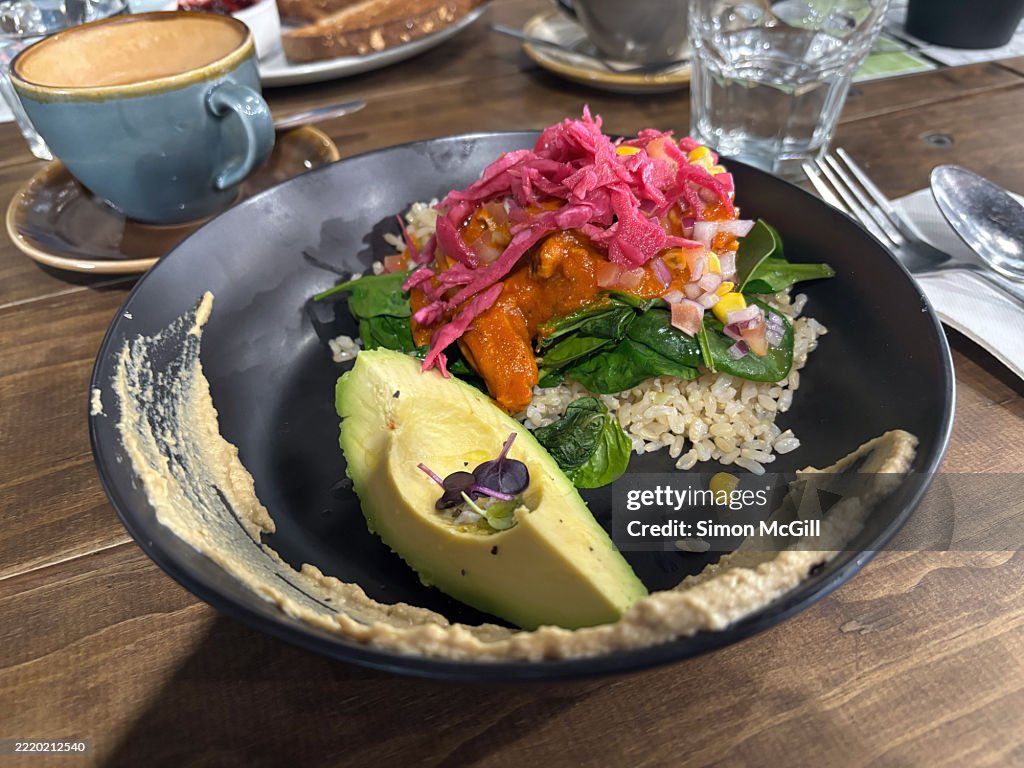 Burrito bowl with chicken, smokey beans, hummus, spinach, brown rice, salsa, pickled red onion, and avocado