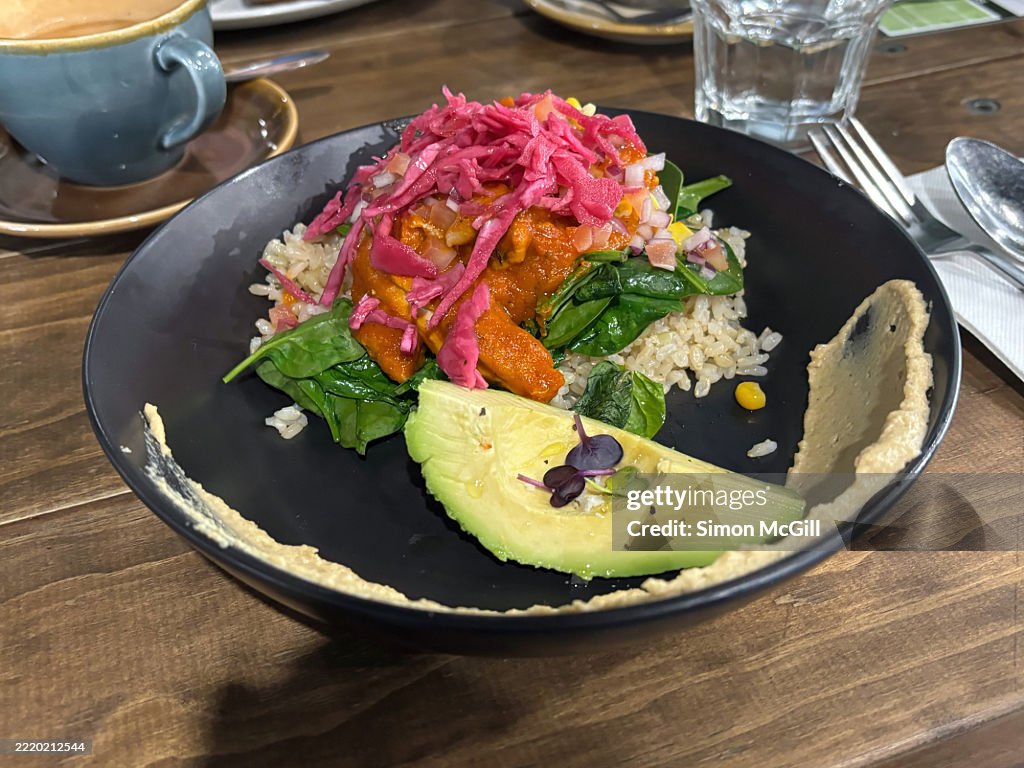 Burrito bowl with chicken, smokey beans, hummus, spinach, brown rice, salsa, pickled red onion, and avocado