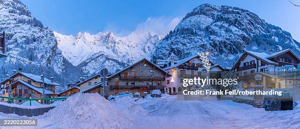view of chalets and snow covered mountains in courmayeur before dawn in winter, courmayeur, aosta valley, italian alps, italy - courmayeur stock pictures, royalty-free photos & images