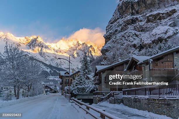 view of hotels, chalets and snow covered mountains in courmayeur at sunrise in winter, courmayeur, aosta valley, italian alps, italy - courmayeur stock pictures, royalty-free photos & images