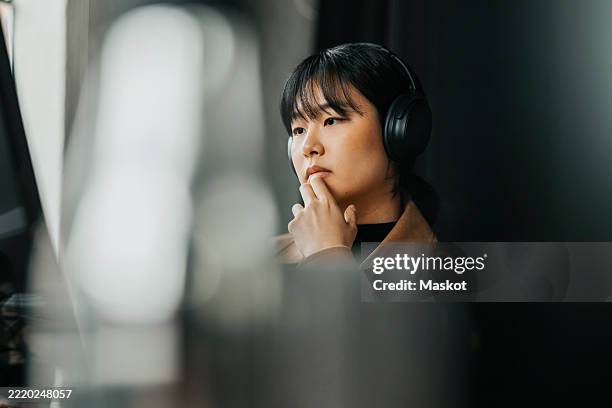 thoughtful female computer programmer working at tech start up office - mise au point photos et images de collection
