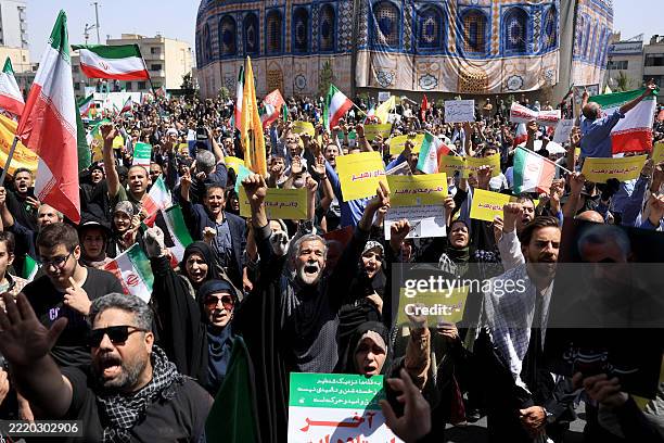 Iranians wave the national flag and chant slogans next to a replica of the Dome of the Rock mosque during an anti-Israeli rally in Tehran on June 20,...
