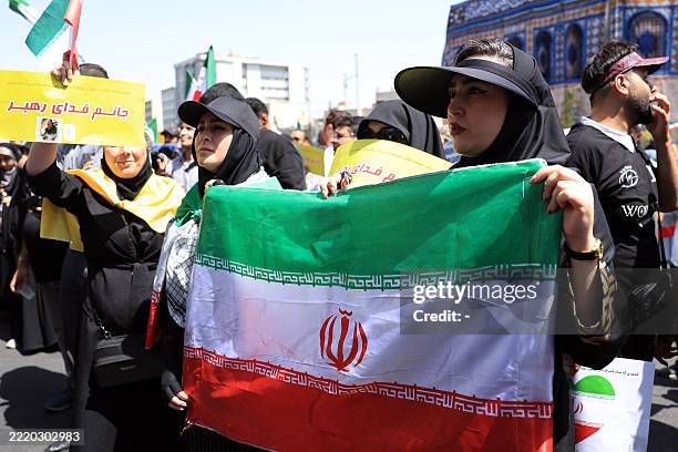 Iranians wave the national flag and chant slogans next to a replica of the Dome of the Rock mosque during an anti-Israeli rally in Tehran on June 20,...