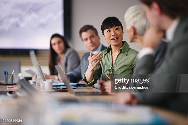 glückliche asiatische geschäftsfrau im gespräch mit ihrem kollegen im büro. - business people stock-fotos und bilder