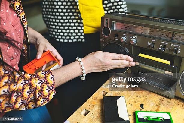 female hand putting in retro audio cassette into tape player - inserting stock pictures, royalty-free photos & images