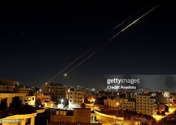 Missiles fired from Iran in retaliation for Israeli attacks are seen in the sky over the Hebron, West Bank on June 21, 2025.