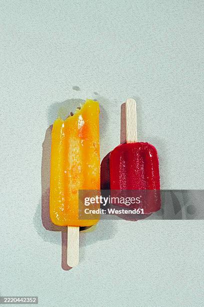 close-up of mango and strawberry popsicles on a sunny day - melting popsicle stock pictures, royalty-free photos & images