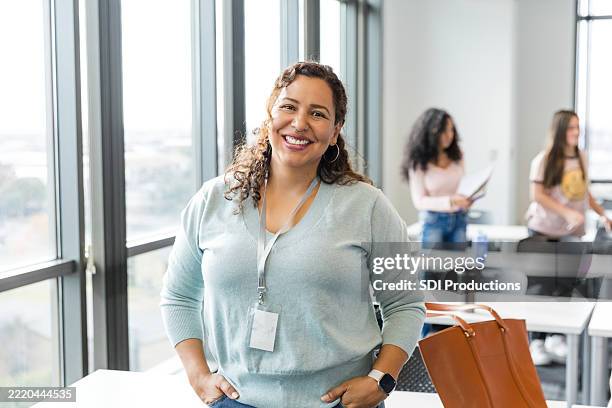 confident mid adult woman smiling in classroom - person of colour stock pictures, royalty-free photos & images