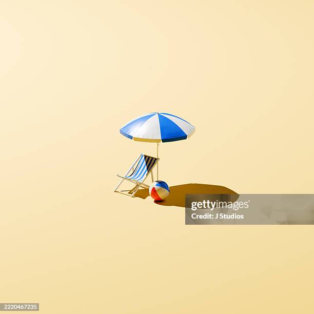 minimal summer setup – beach essentials in sunlight with space to breathe - silla de playa fotografías e imágenes de stock