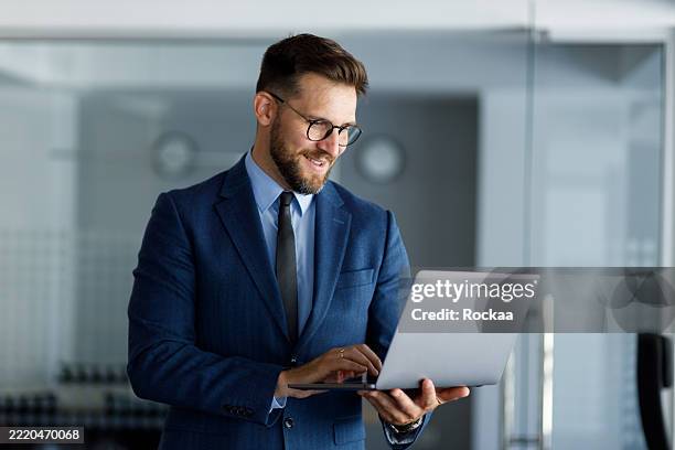 frappe professionnelle réussie sur un ordinateur portable, travail intensément dans un espace de travail élégant avec une expression concentrée et un comportement confiant - homme costume photos et images de collection