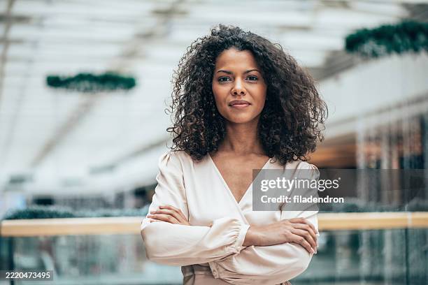 confident businesswoman in a bright office - autoriteit stockfoto's en -beelden
