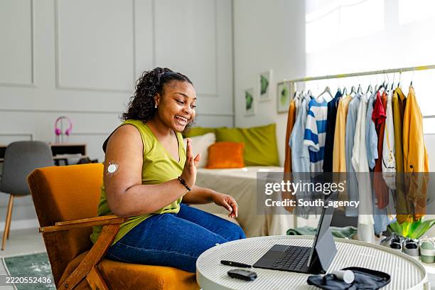 young black woman engaging in a virtual conversation while managing type 1 diabetes at home - type 1 diabetes stock pictures, royalty-free photos & images