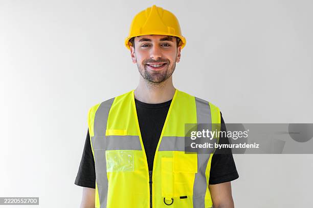 handsome male worker wearing a safety helmet - waistcoat stock pictures, royalty-free photos & images