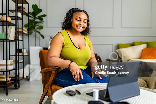 young black woman with type 1 diabetes engages in an online support group session from her cozy living room - type 1 diabetes stock pictures, royalty-free photos & images